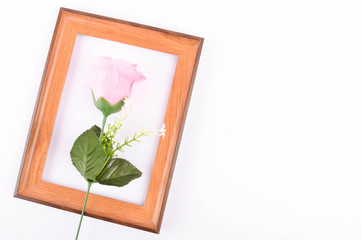 Flat lay view of artificial red roses with heart shape and wooden frame on white background. Love and Valentine's Day concept.