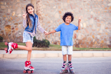Two happy kids boy and girl roller skate in the park. Children and activity concept