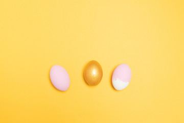 Gold and pink egg on a yellow background