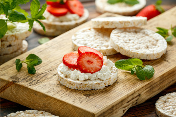 Rice crackers with ricotta and strawberries on wooden board. healthy food