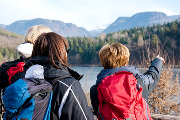 3 donne di mezza età osservano il panorama montano di un lago in Italia