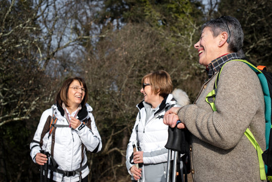 3 donne ridono e parlano tra loro durante una passeggiata in montagna
