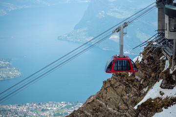 Fototapeta premium Red cable car move in to station at the top of Pilatus mountain with beautiful view background , copy space , Lucerne , Switzerland