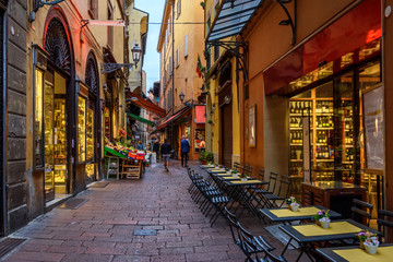 Old narrow street in Bologna, Emilia Romagna, Italy. Architecture and landmark of Bologna. Cozy cityscape of Bologna. - obrazy, fototapety, plakaty