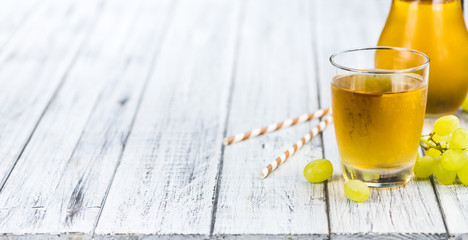 Portion of healthy Grape Juice on an old wooden table (selective focus; close-up shot)