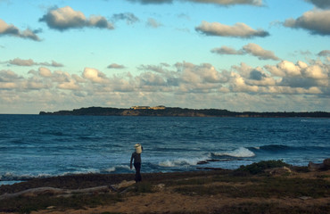 Fototapeta na wymiar a fisherman walks along a wild beach on the Atlantic ocean coast. Dominican Republic