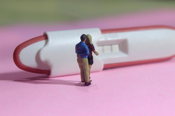 Fototapeta na wymiar illustation photo for Lovely moment, Young Couple Mini figure Toy kissing beyond Pregnancy test pack with positive result