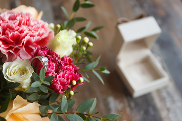 Silver ring and a bouquet of flowers, blurred background