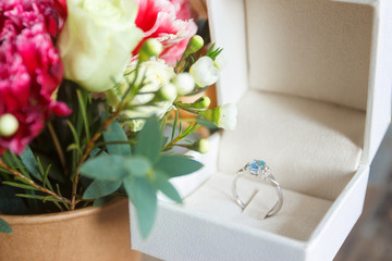 Silver ring and a bouquet of flowers, blurred background
