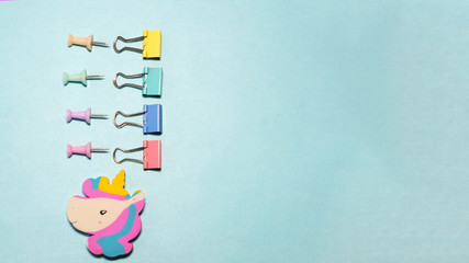 Four binder clips isolated on blue background.