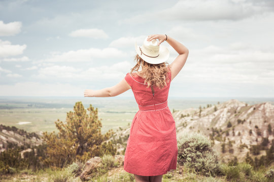 Young girl with cowboy hat dancing in a rural prairie setting. Cody, Wyoming, USA
