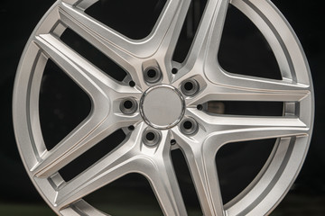 alloy wheel silver, rim new car wheel on a black background close up
