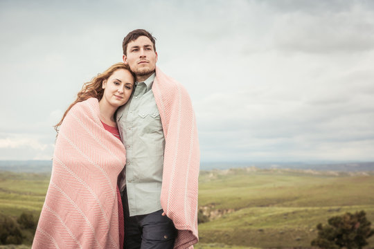 Couple dressed in vintage clothes hugging each other in a rural prairie setting. Cody, Wyoming, USA