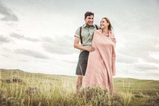 Couple dressed in vintage clothes hugging each other in a rural prairie setting. Cody, Wyoming, USA