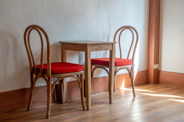 Fototapeta na wymiar The small table and chairs in the small rome next to the window and natural light from the outside. 