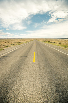 Straight road through a rural prairie countryside. Cody, Wyoming, USA