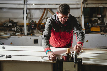 Process of production and manufacture of wooden furniture in furniture factory. Worker carpenter...