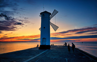 Tourists at the windmill shaped lighthouse on the Baltic Sea in Swinemünde. Swinoujscie, Poland