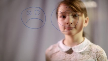 the development of emotional intelligence. child psychology. the girl and draw happy and sad emoticons