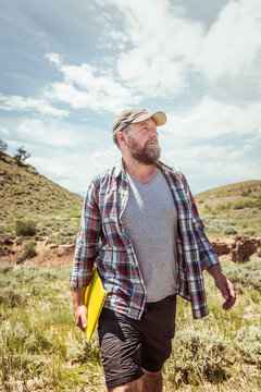 Man surveying and studying a rural prairie setting. Bridger, Montana, USA