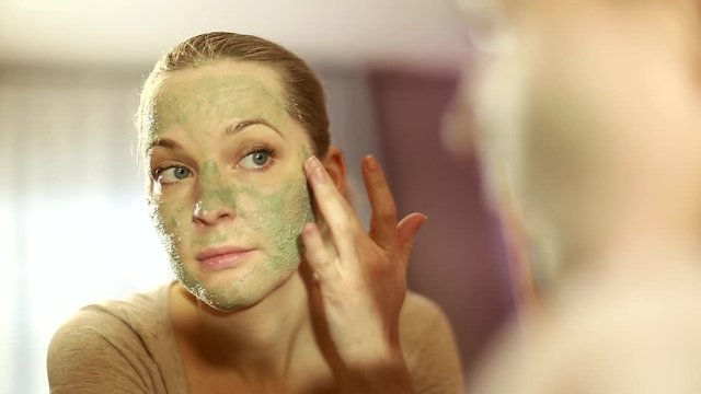 girl looks in the mirror, not pleased with the appearance, pulls the skin. Ugly, aging skin. Allergic to cosmetics, fear of aging, under eye circles, wrinkles. Low self-esteem, dysmorphic disorder. 