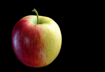 Yellow red apple on a black background.