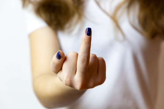 Closeup of hands with classic blue manicure showing middle finger in "fuck off" gesture.