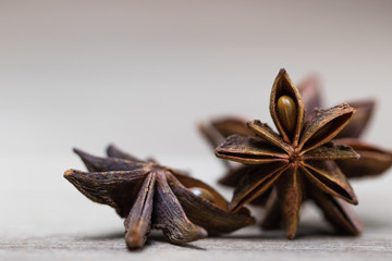 star anise with or without seed, closed, on a light wooden surface. spice for the recipe. beautiful picture, background.