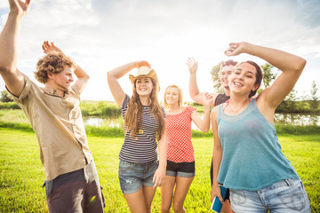 Group of young adults having a picnic party near a swimming lake. Bridger, Montana, USA