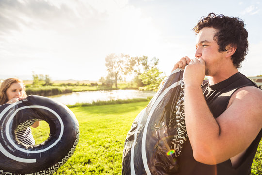 Two young adults blowing up swimming rings at a swimming lake. Bridger, Montana, USA