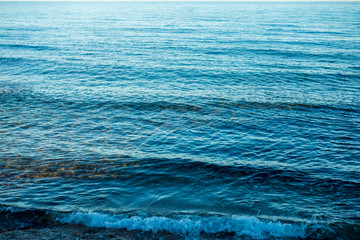Calm waves on the shore of the blue sea