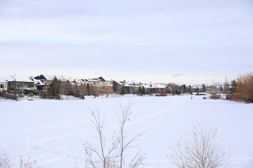 Obraz premium A Perfect Neighborhood along a Frozen River in Canada.