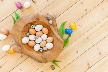 easter background decoration with eggs in wooden bowl and green leaves on wooden floor. Spring decoration. Naturally designing sustainable old building