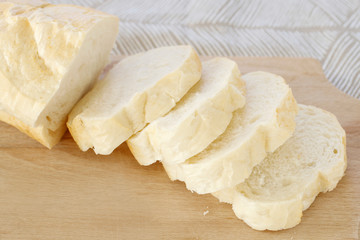 Sliced bread on wooden cutting board.