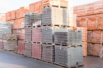 pallets with bricks in the building store. Racks with brick. Masonry, stonework. Several pallets with concrete brick stacked on top of each other in depot. new bricks on pallets