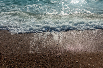 Calm waves on the shore of the blue sea