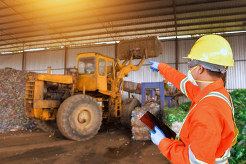 workers talking in recycling factory,a worker who recycling thing on recycle center,engineers standing in recycling center