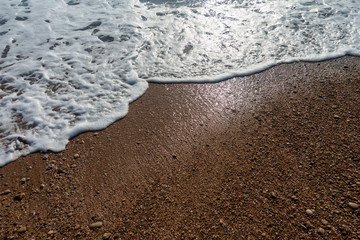 Calm waves on the shore of the blue sea