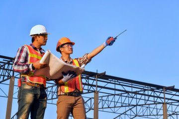Construction engineers supervising progress of construction project stand on new...
