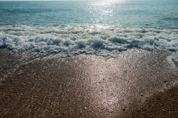 Calm waves on the shore of the blue sea