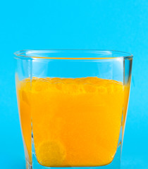 Close-up of painkiller pills in a glass of water.