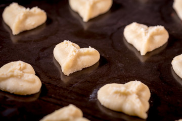Heart shaped butter spritz cookies on baking sheet selective focus