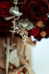 A bouquet of roses is hanging in front of a out of focus brown and white background