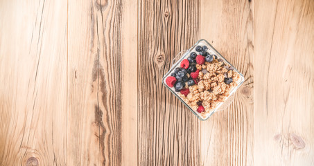 Breakfast of granola and wild berries. Delivered in a glass plate