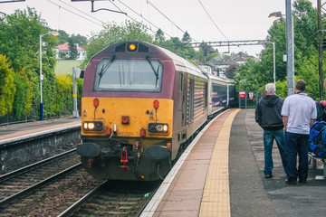 Famous scottish caledonian sleeper train is arriving to a platform on a train station on its way to...