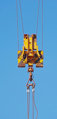 Fototapeta premium Crane hook hanging on steel ropes isolated on background sky