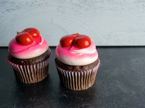 Two Chocolate Cupcakes Decorated With White And Pink Frosting And Red Hearts On A Black Slate And Gray Shiplap Background, Perfect For Love, Valentine’s Day, Mother’s Day Or A Birthday!