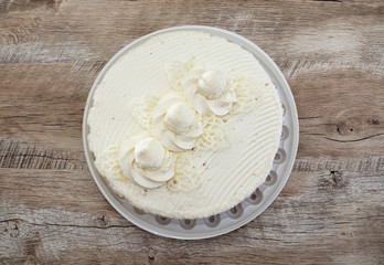 tasty, white cake with cream on a wooden background. View from above.