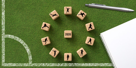 number 2020 on cubes lying on green grass background