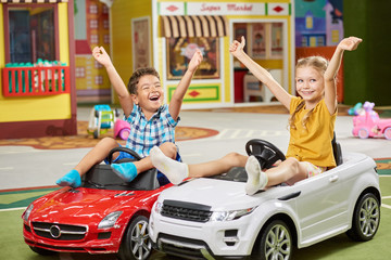 31.07.2017 - Kyiv, Ukraine. Little boy pushing toy car indoor. Two happy kids playing with toy car....